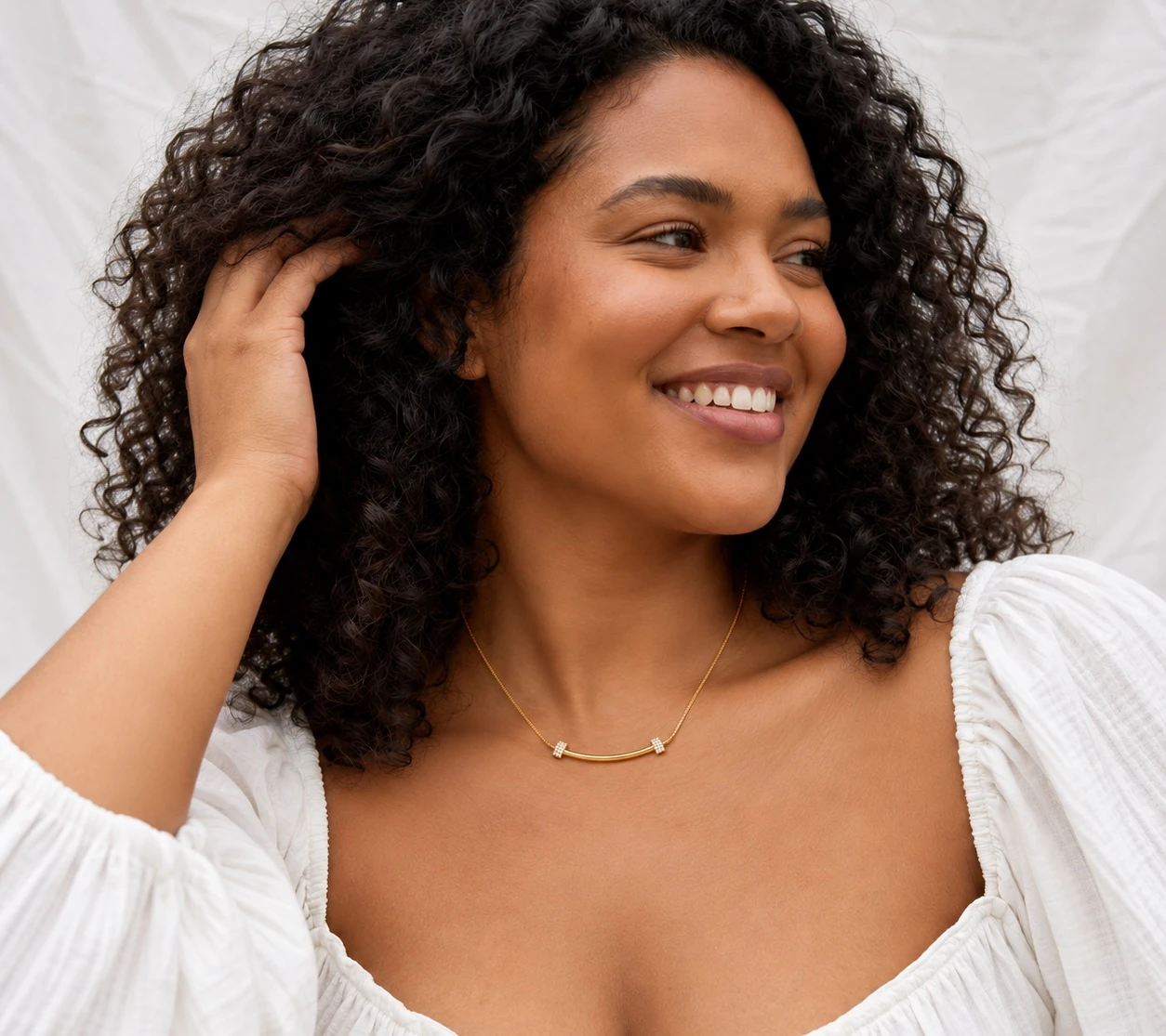 Lachend model draagt de Arc Bar Necklace bij een witte blouse