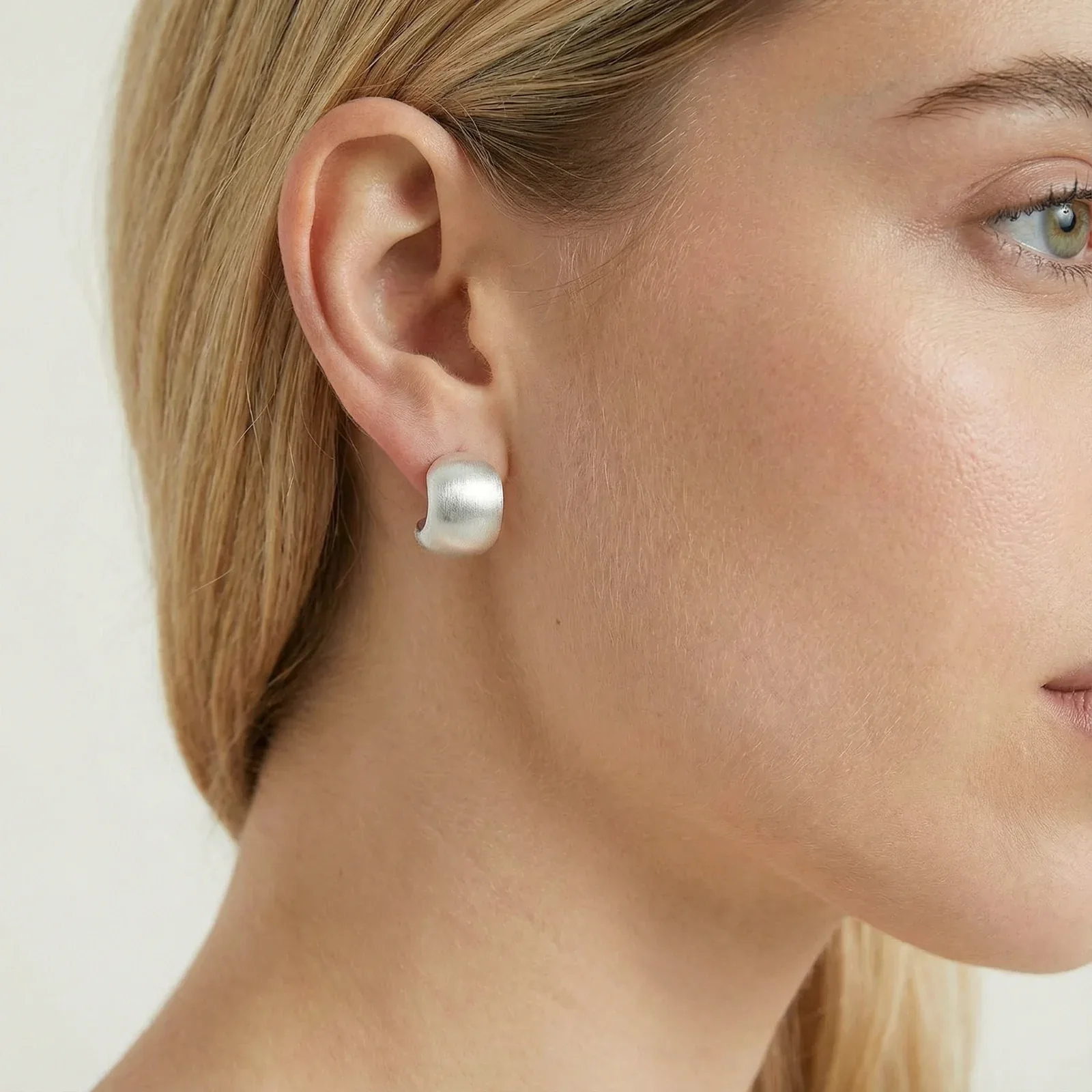 Model draagt de Brushed Dome Studs, close-up van het oor in profiel