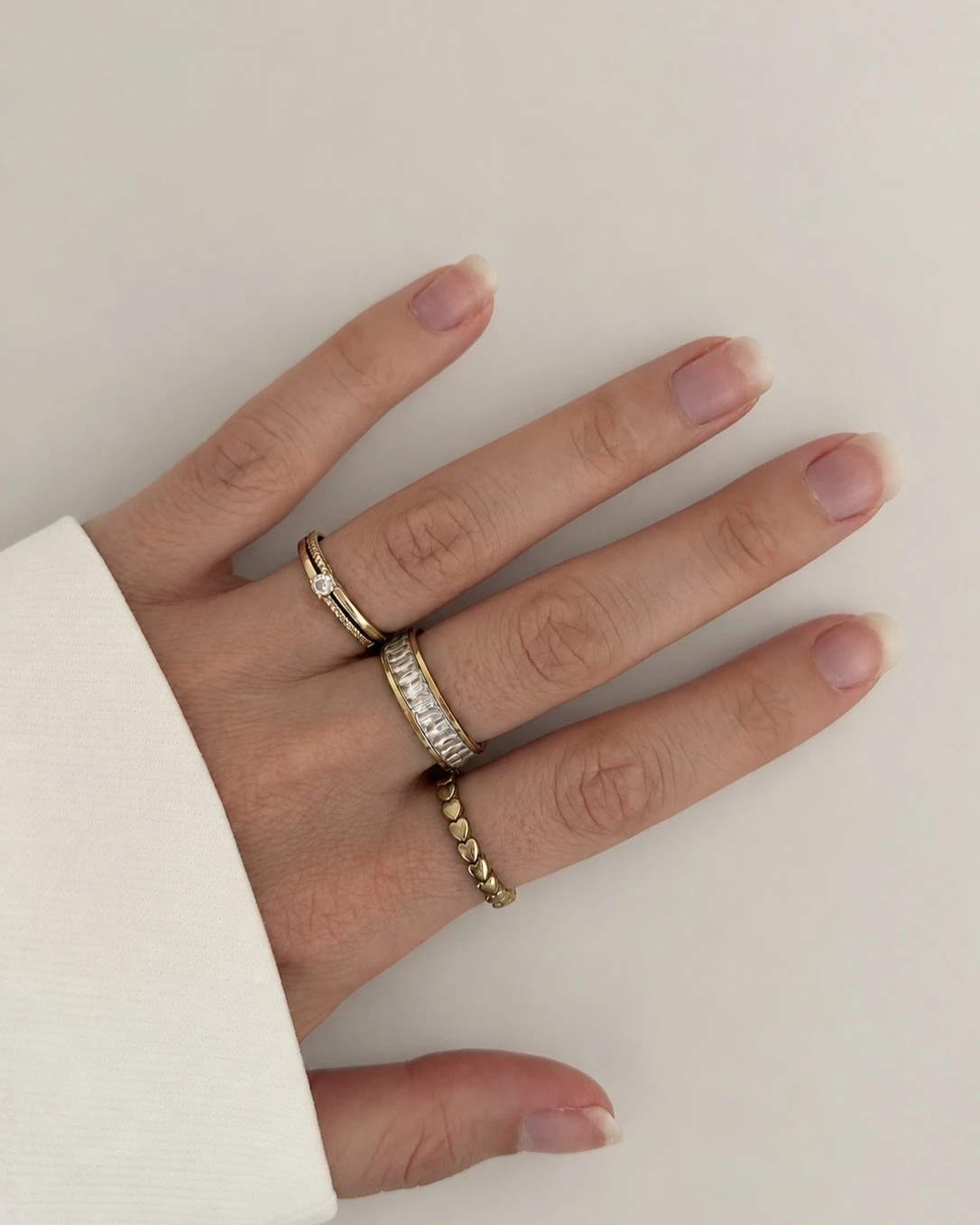 Hand met gestapelde ringen, waaronder de Eternity Ring